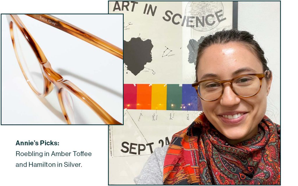 Image of round glasses in Amber Toffee and woman wearing the glasses in front of a poster