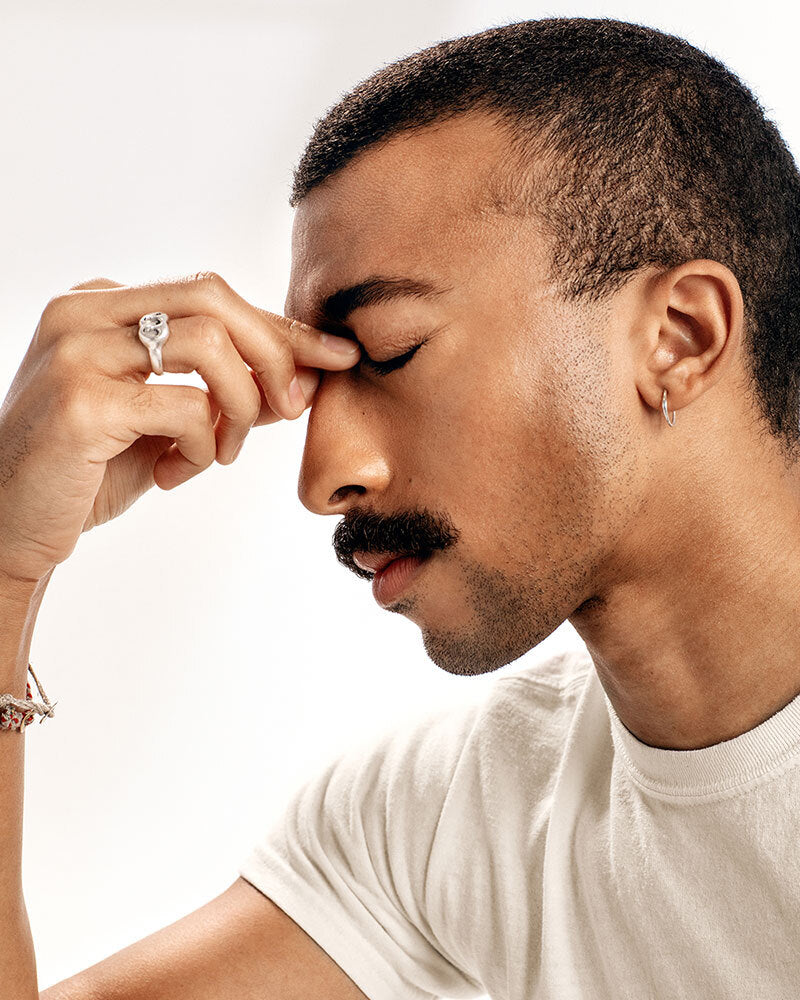A man holding his nose bridge in discomfort