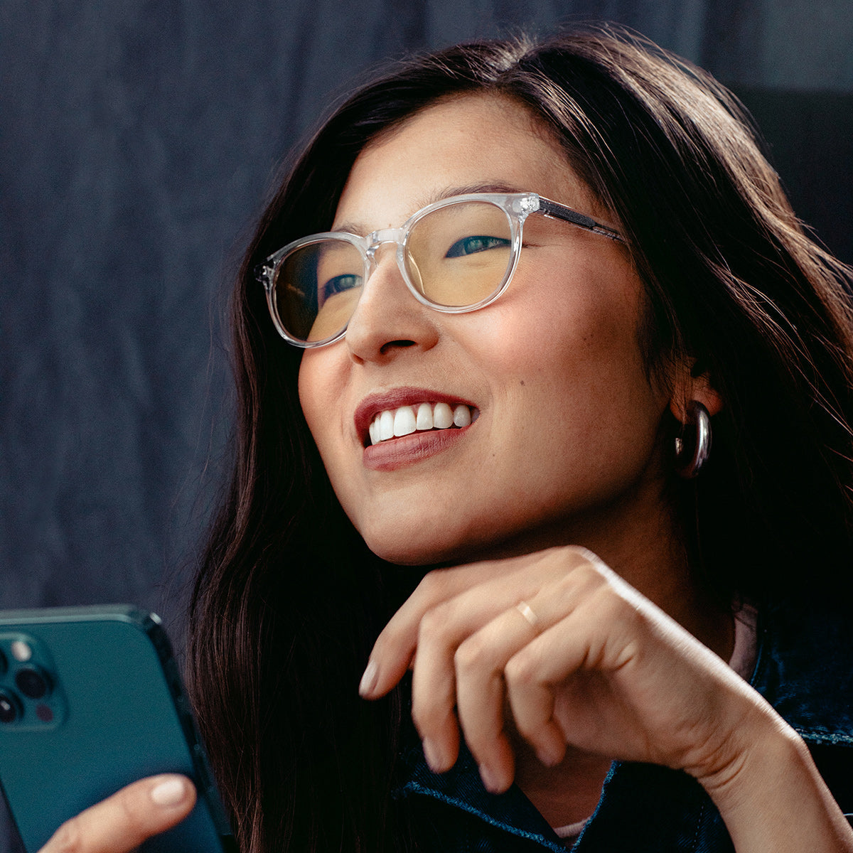 Asian woman wearing glasses with phone in hand