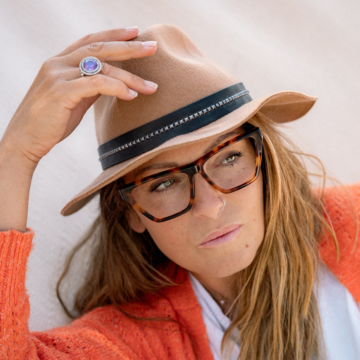 Woman wearing hat and eyeglasses dreamy look