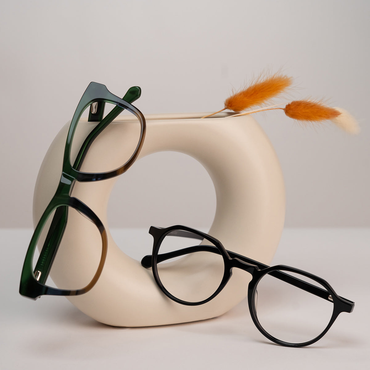 two eyeglasses displayed on art object