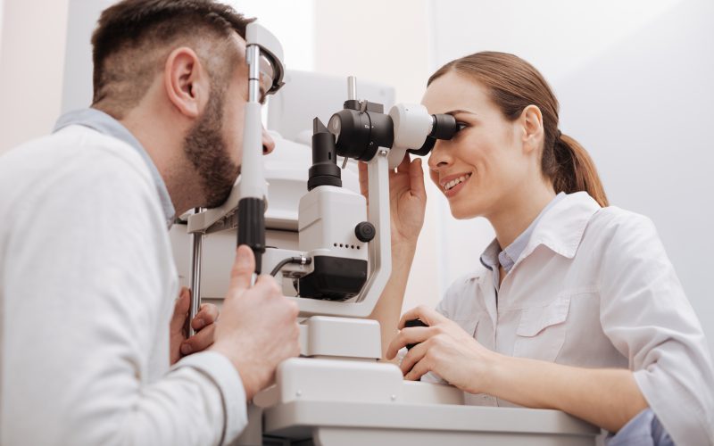 Man and woman looking into a machine for an eye exam