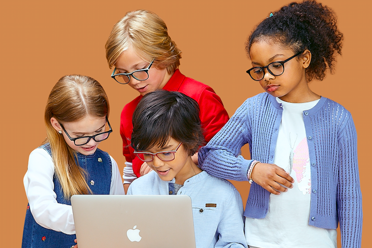 A group of 4 kids wearing blue light glasses looking at a laptop