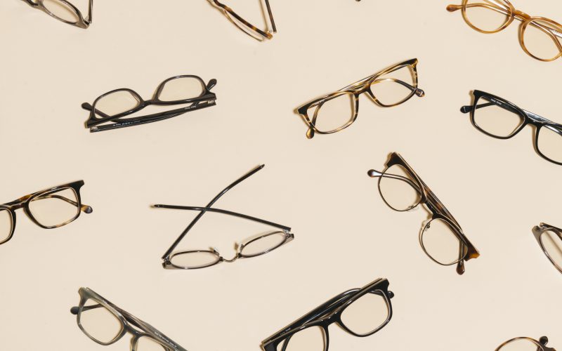 A variety of Felix Gray eyeglasses on a tan background
