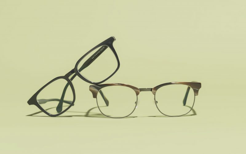 Two pairs of Felix Gray glasses on a green background