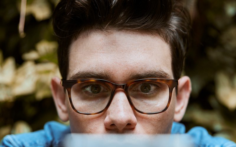 Man wearing eyeglasses looking at his phone