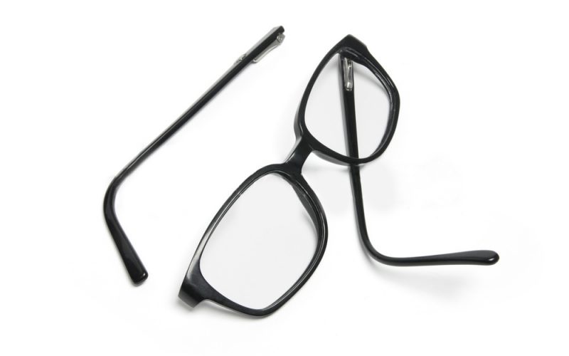 A pair of broken black glasses