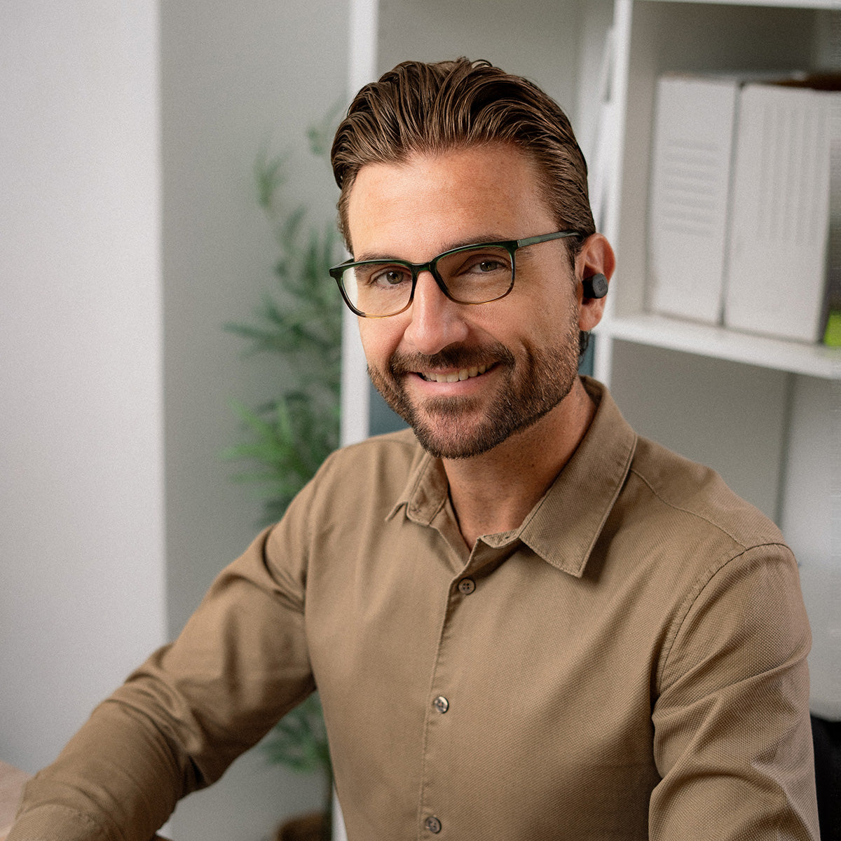 Man wearing glasses and headphones in office
