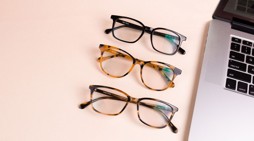 Three Felix Gray glasses next to a laptop