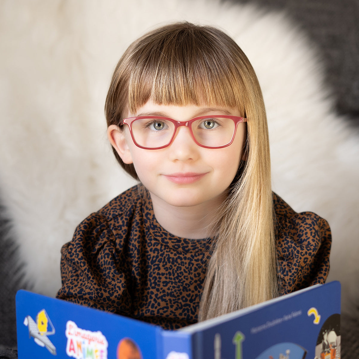 Girl wearing red glasses reading book