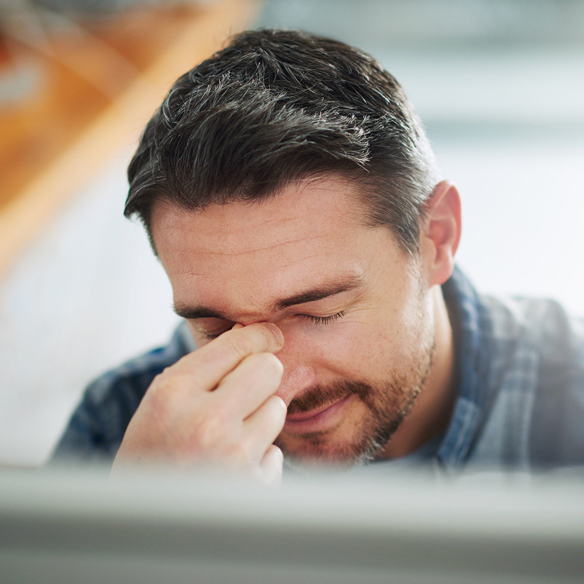 Man rubbing his eyes experiencing digital eye strain