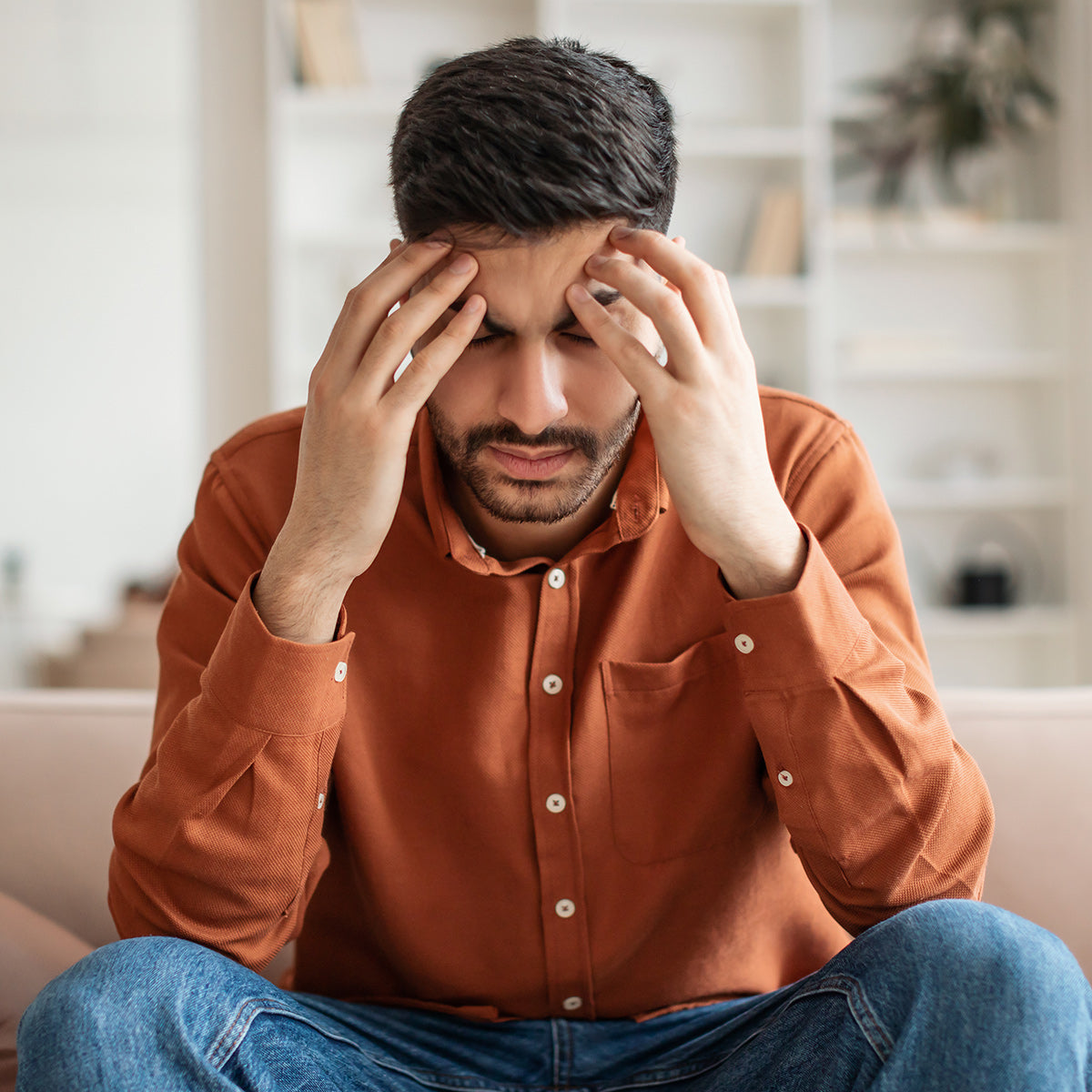 Man with migraine headache holding head