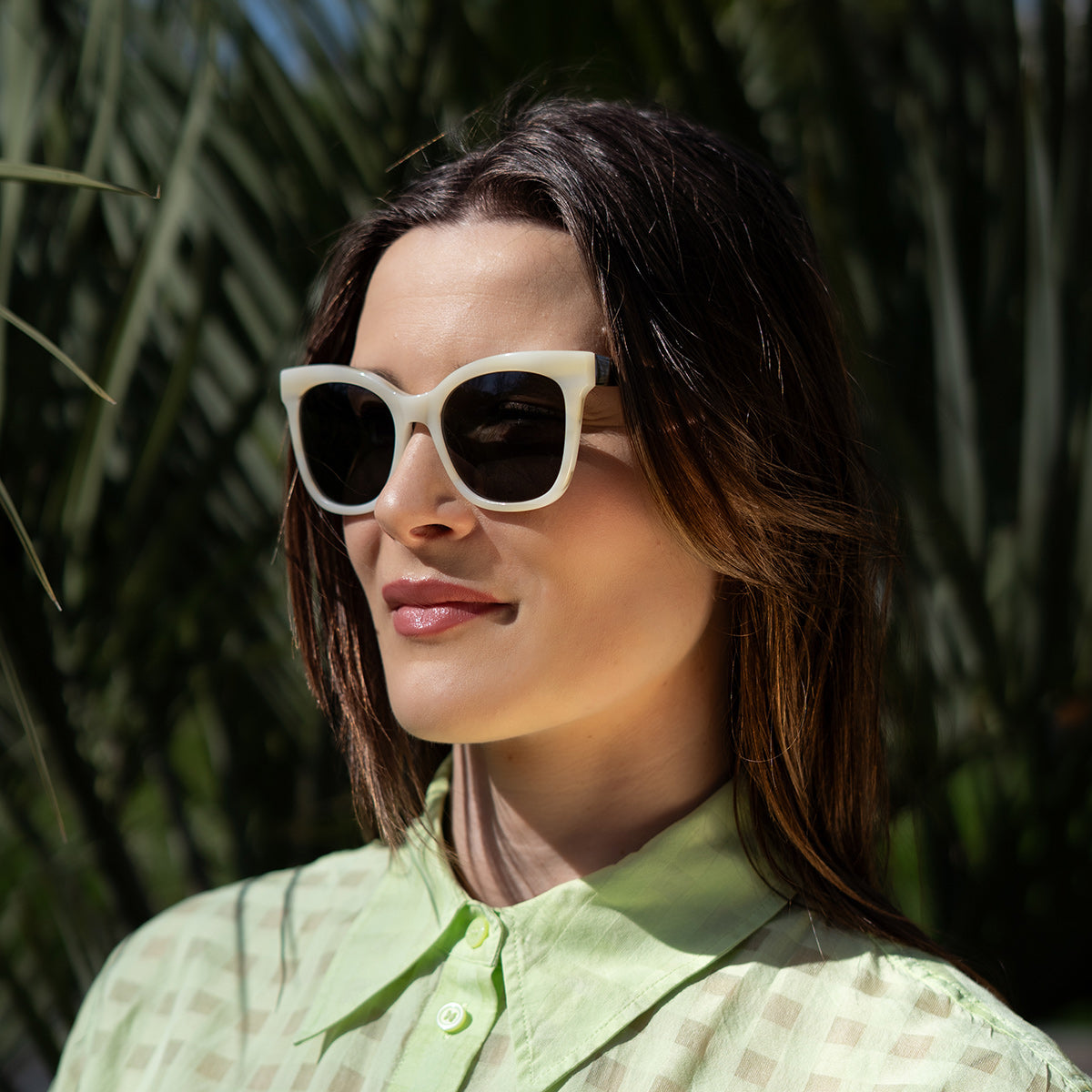 Woman wearing sunglasses on sunny day in garden